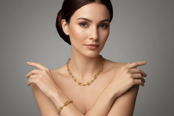 Woman wearing gold jewelry against a gray background