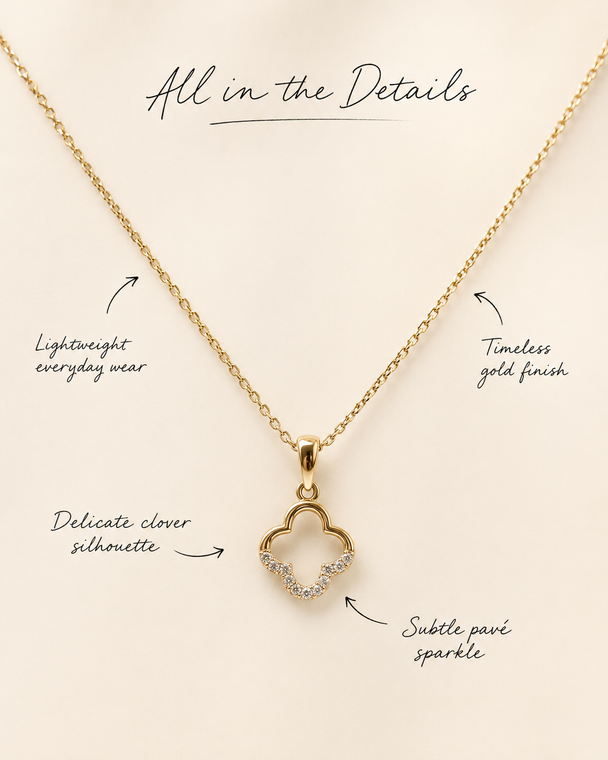 Gold necklace with clover pendant on a beige background