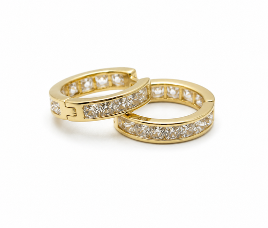 Two gold hoop earrings with diamond accents on a white background