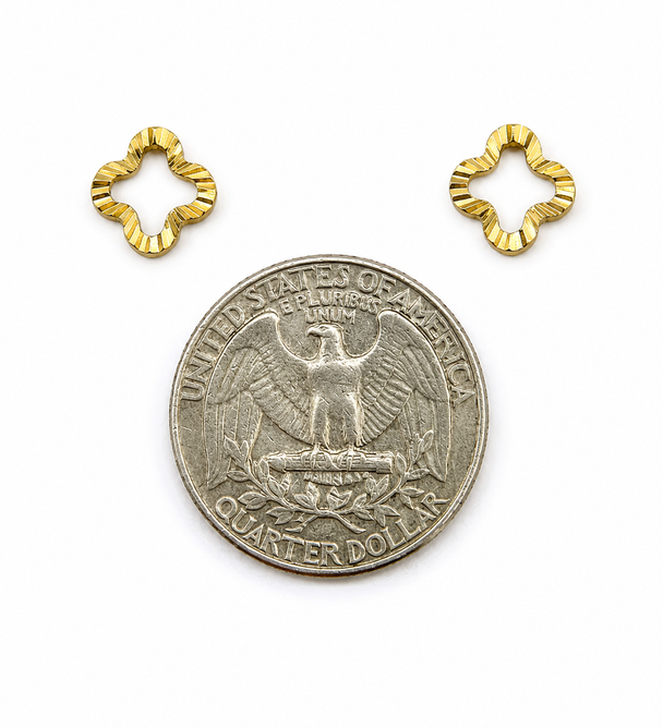Gold flower-shaped earrings next to a US quarter for size reference