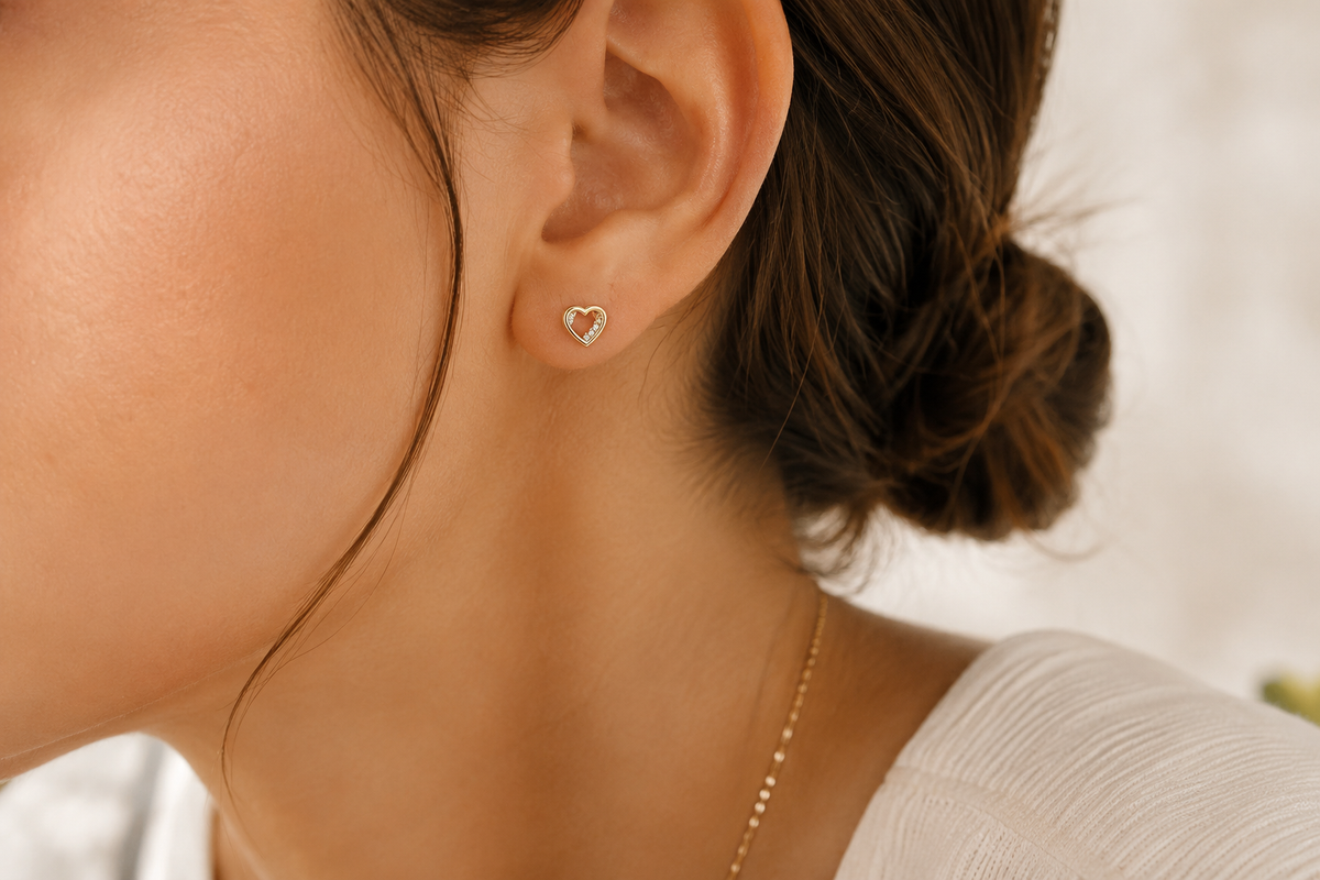 Heart-shaped earring worn by a person with a blurred background
