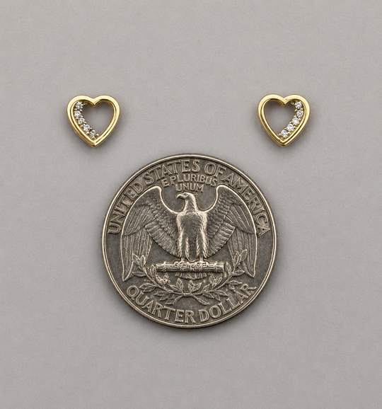 Silver quarter dollar coin with two gold heart-shaped pendants on a gray background