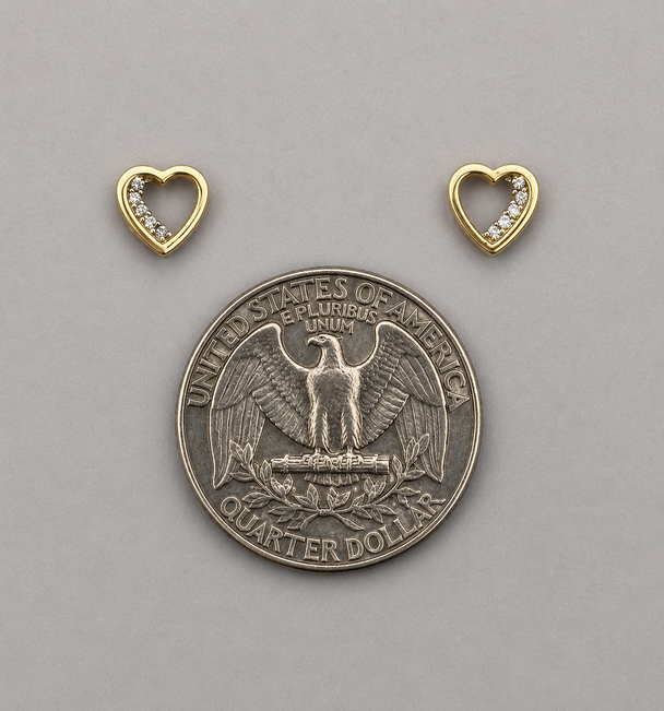 Silver quarter dollar coin with two gold heart-shaped pendants on a gray background